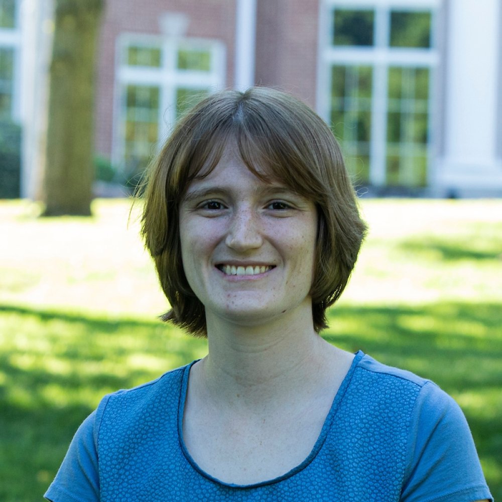 lady with short brown hair wearing blue top in front of student center