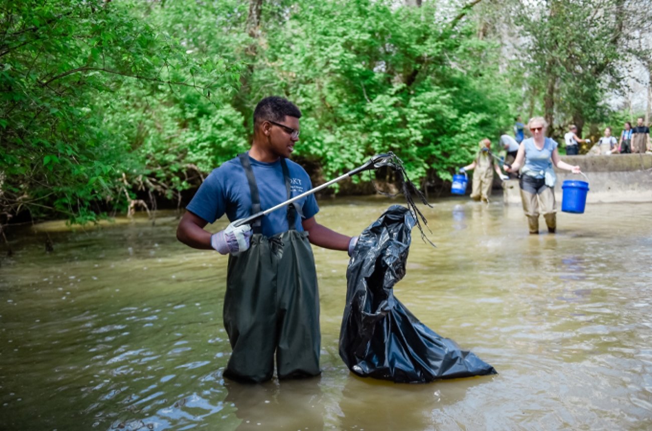 Student cleaning up river