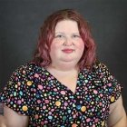 Person wearing colorful top and smiling at photographer