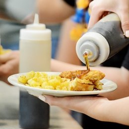 Student pouring syrup over breakfast food