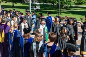 Honor walk ceremony where students in regalia walk past all their faculty members who are clapping for them at commencement.