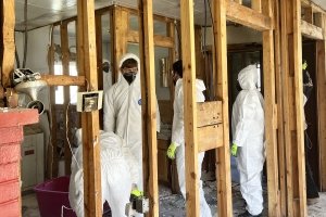 Centre College students dress in white protective overalls as they demo the interior of a North Carolina home affected by flooding.