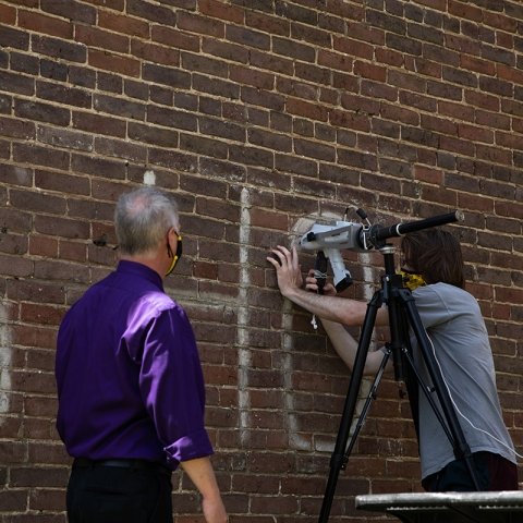 Faculty member and student inspecting the details of the age of the paint used in C6H0