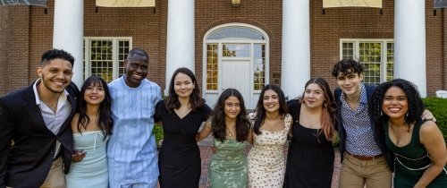 Group of students lined up facing camera and smiling
