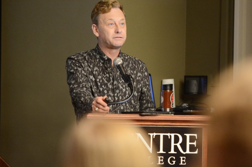 A man speaks from behind a lectern.