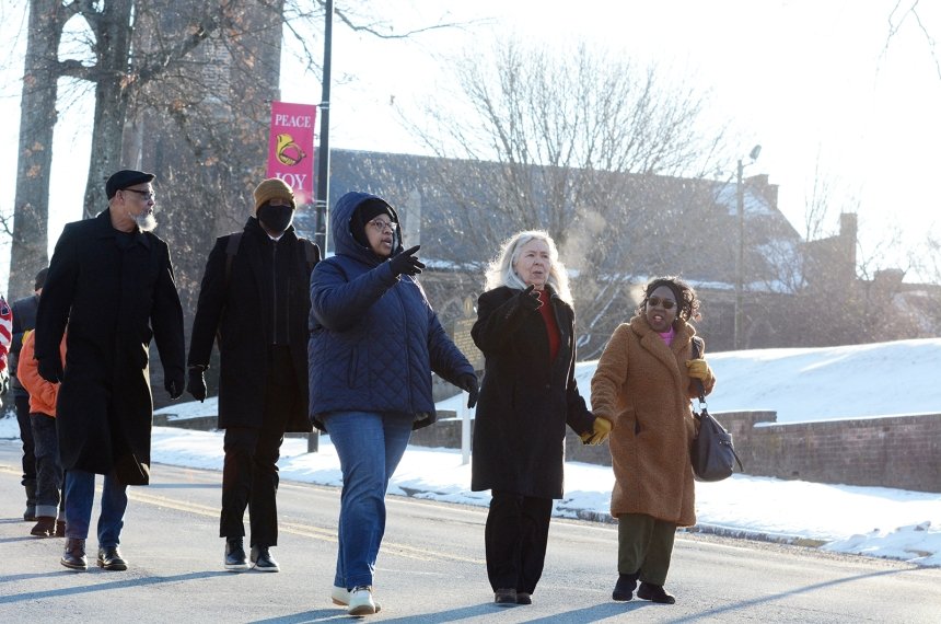 Three women lead marchers down the street to the Centre College campus.