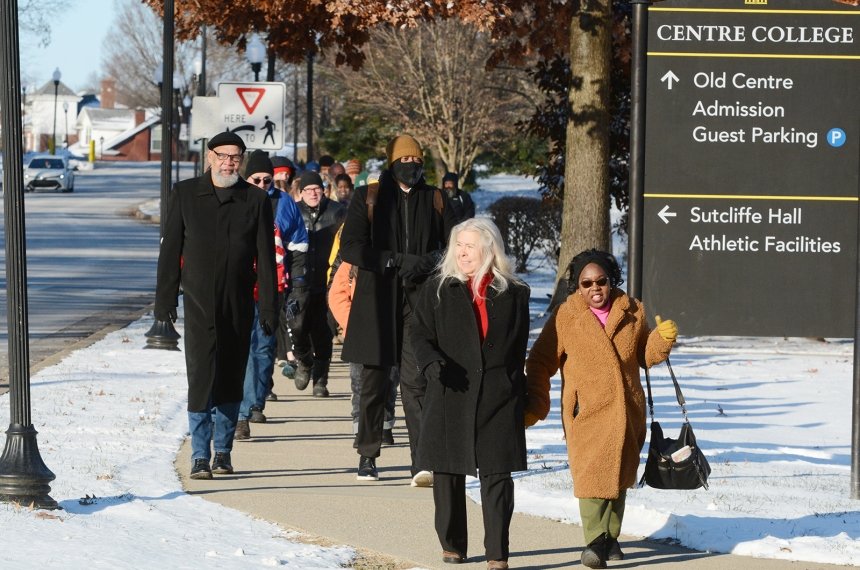 Two women lead a throng of marchers past a Centre College sign during the Martin Luther King Jr. Day march.