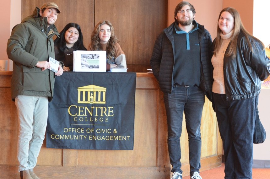 Two men and three women pose for a photo next to a sign that says "Centre College Office of Community and Civic Engagement."