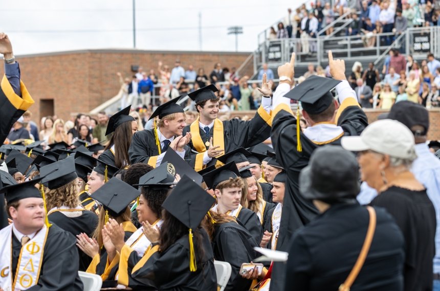 Graduates wave to the crowd