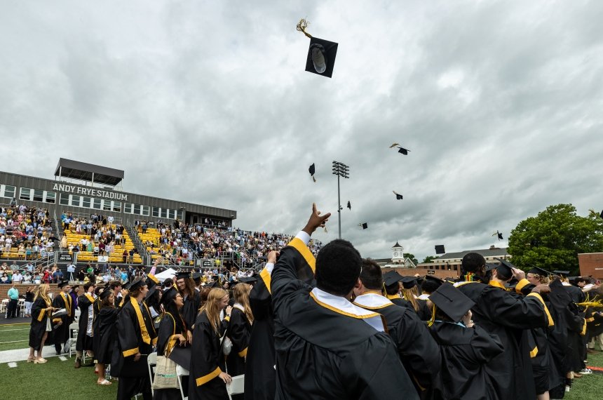 Graduates throw their caps