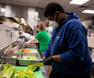 Person cutting up celery in a commercial kitchen for food recovery