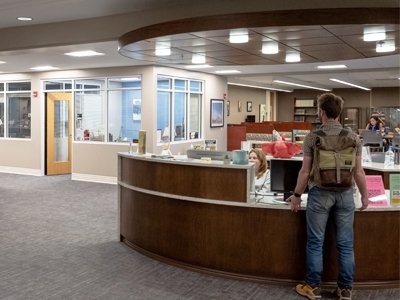 Student standing at checkout area in the library