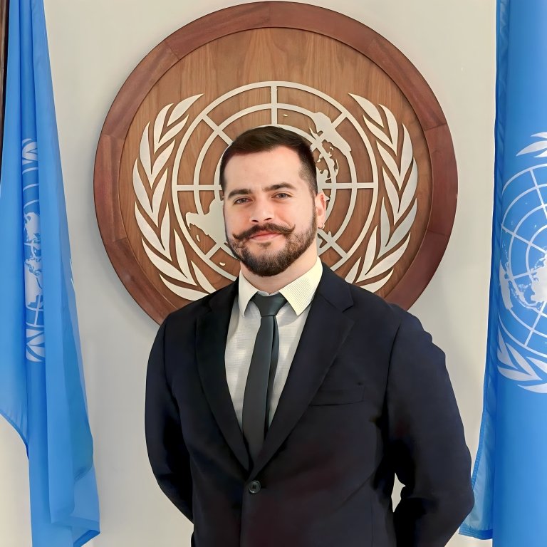 Matheus Marlisson poses for a photo in front of the United Nations Seal. 