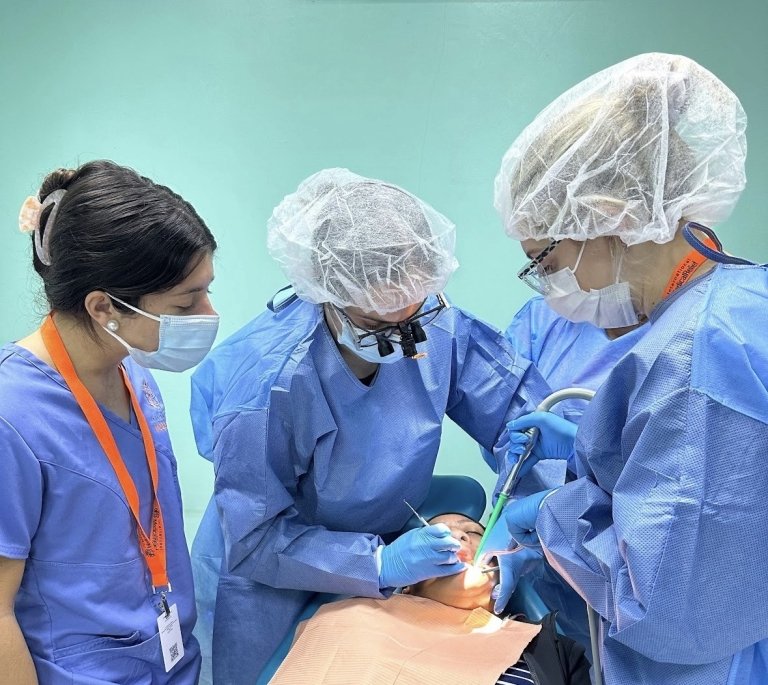 Nicole Limehouse observes as three dental professionals provide service to a patient.