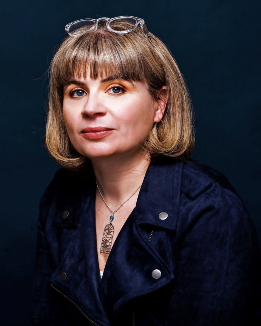 A person with short blond hair poses for a photo. 