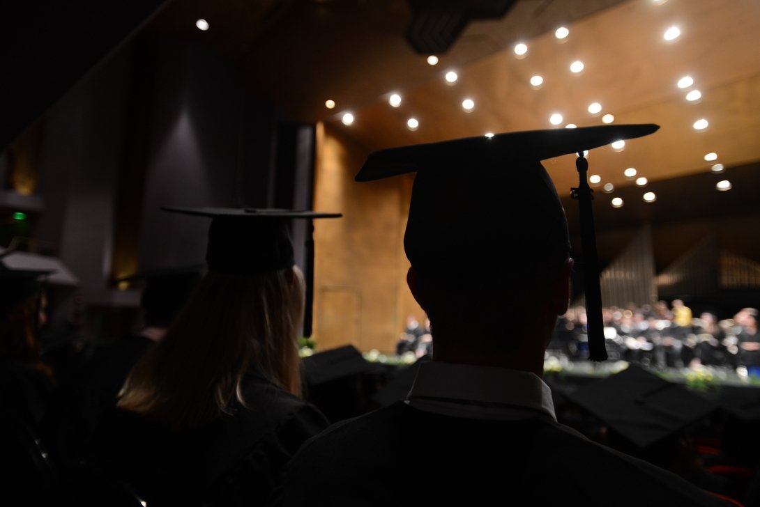 A silhouette of a student wearing a graduation cap and tassel. 