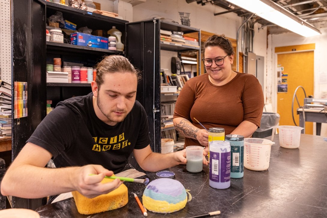 Stephanie Galli watches over Joplin Hora who glazes his bowl.