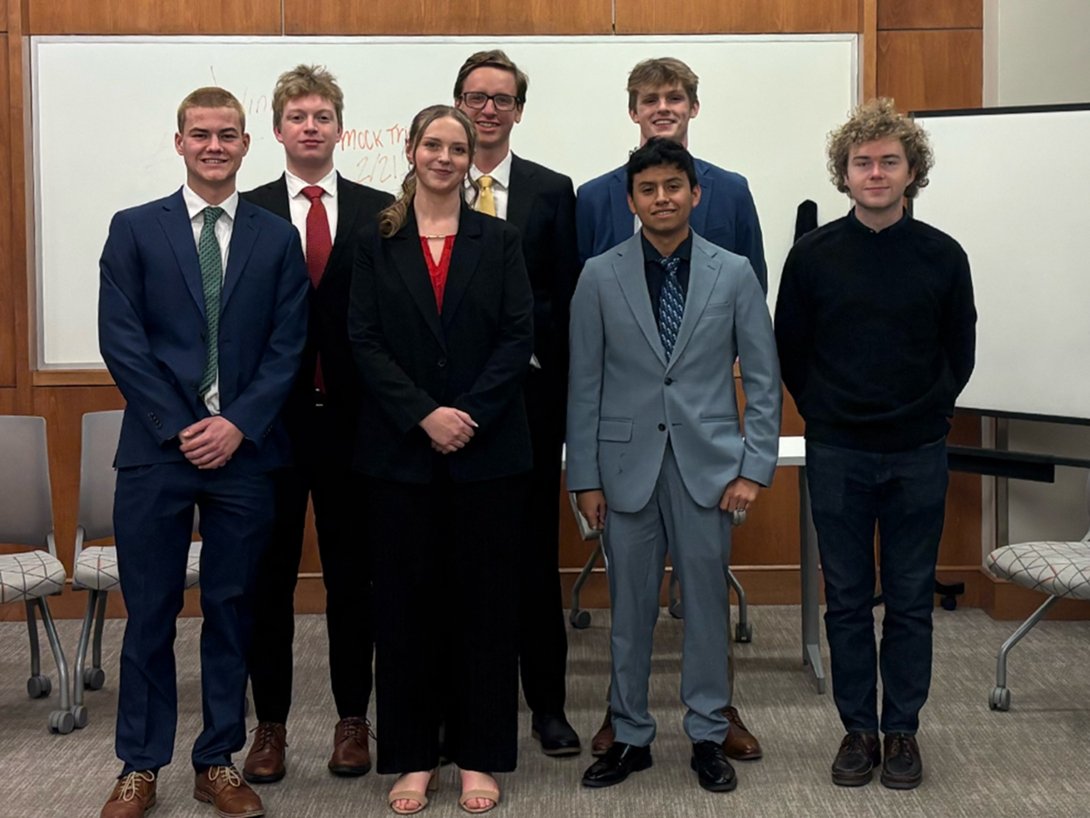The new mock trial team posing in the court room. It is a group of seven students.