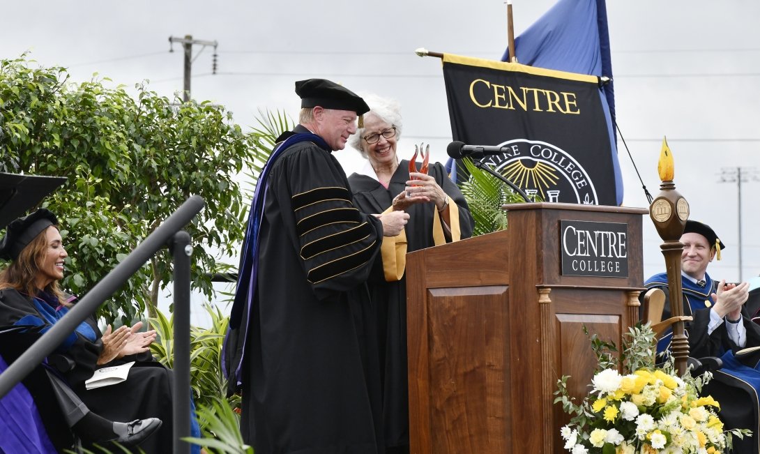 Centre College president Milton C. Moreland hands a glass award to retiring trustee Crit Blackburn Luallen.
